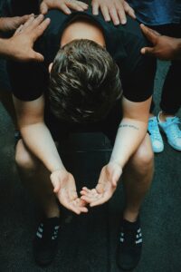 Supportive hands on person's shoulders, seeking comfort.