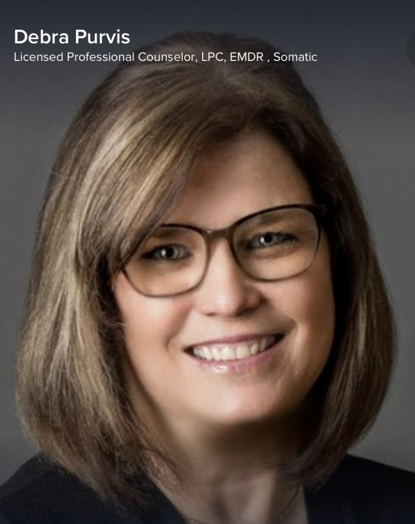Licensed professional counselor smiling with glasses.