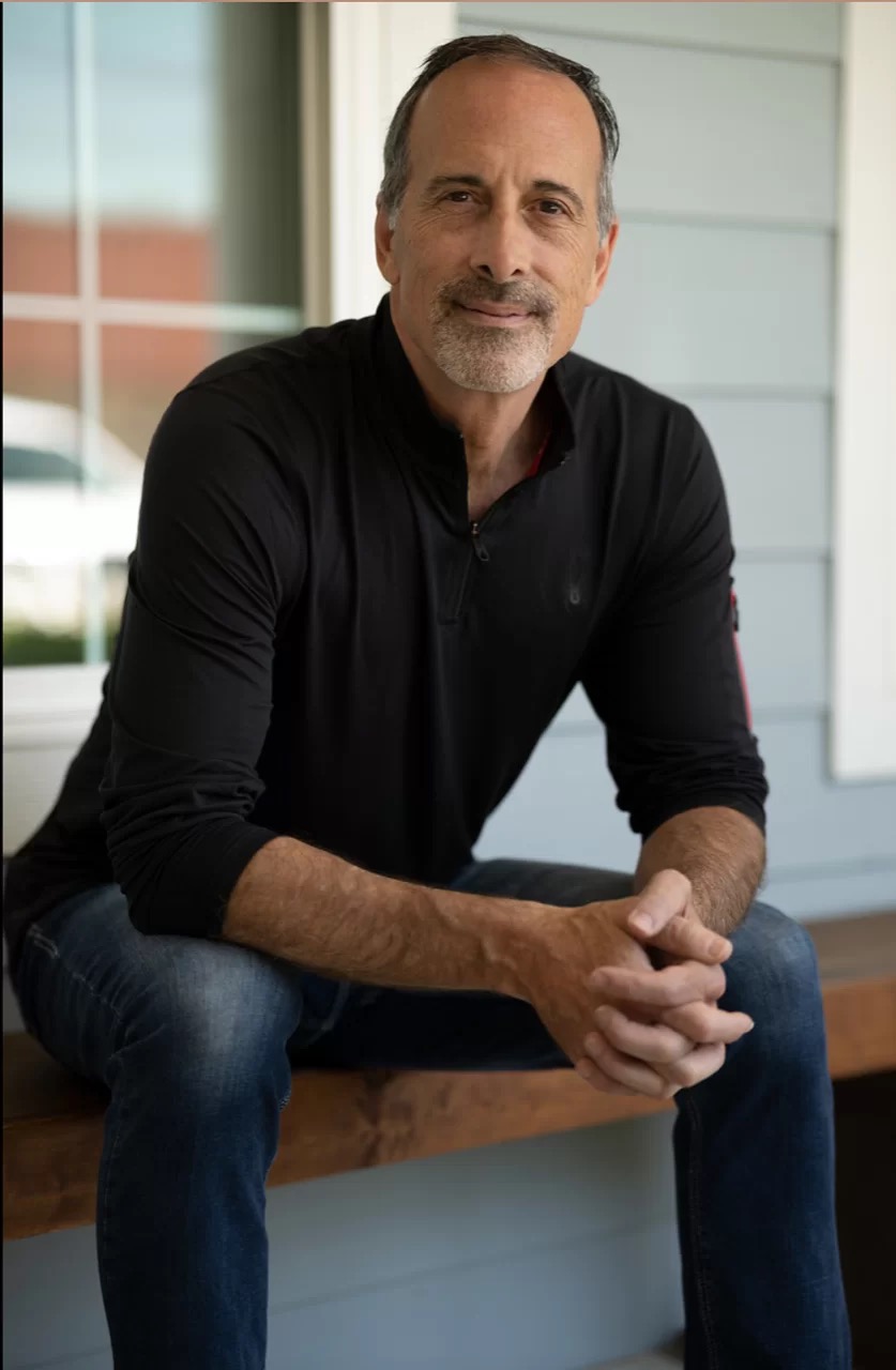 Man sitting on porch, wearing black shirt